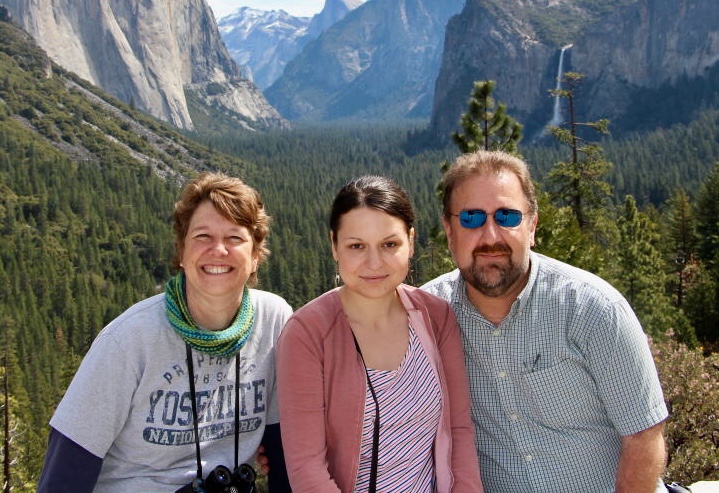 Brian and Sheila Green, smiling with their first fellow, Anna, at Yosemite National Park