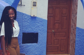 Ermida, during her CLS exchange, standing in a bright blue doorway