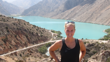 Abigail smiles for the camera while visiting a scenic mountain and lake in Tajikistan