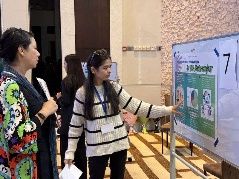 Woman presents poster at conference