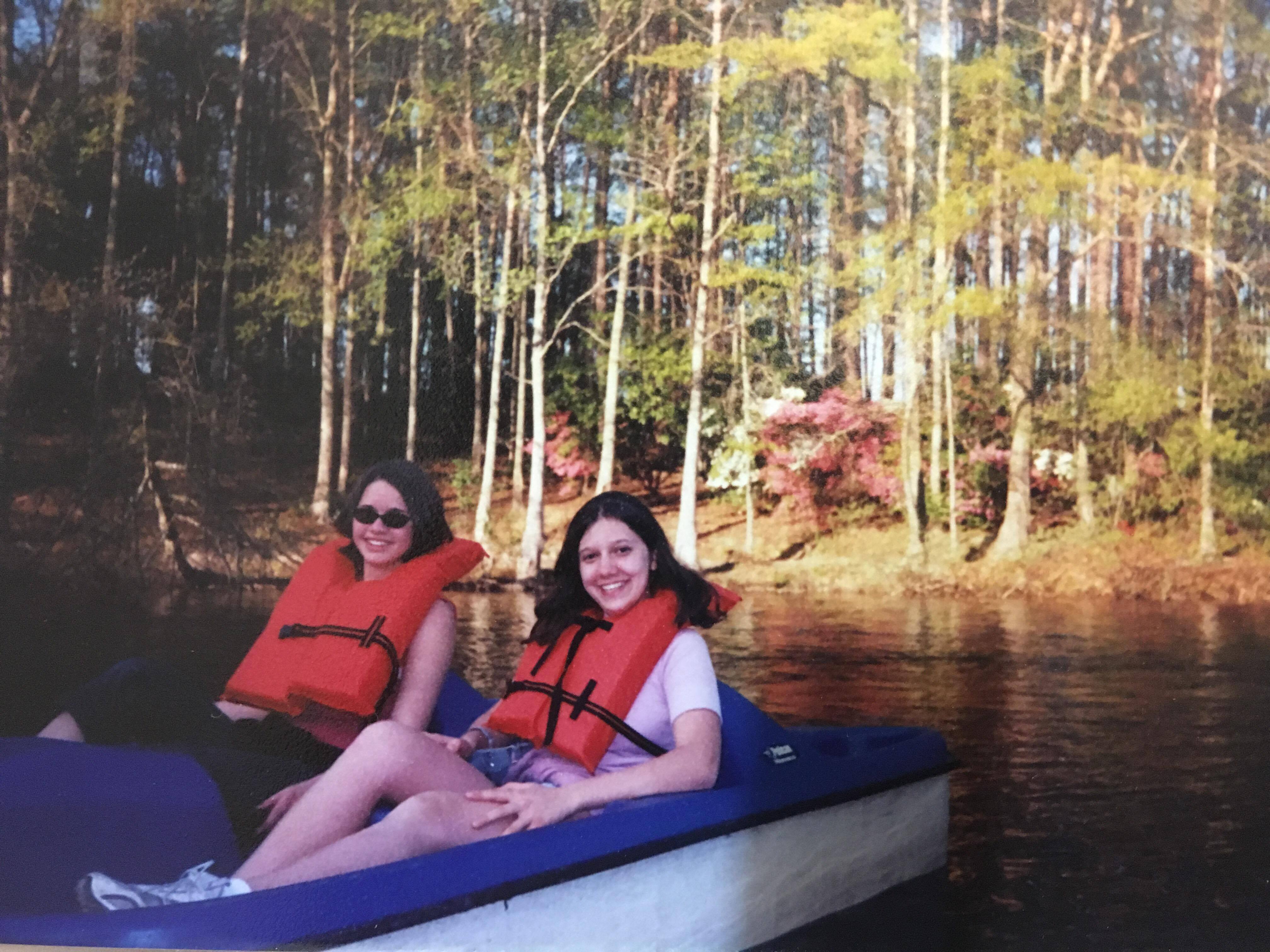 Host sister Alex and Tatyana on a paddle boat, smiling in their life jackets in 2004