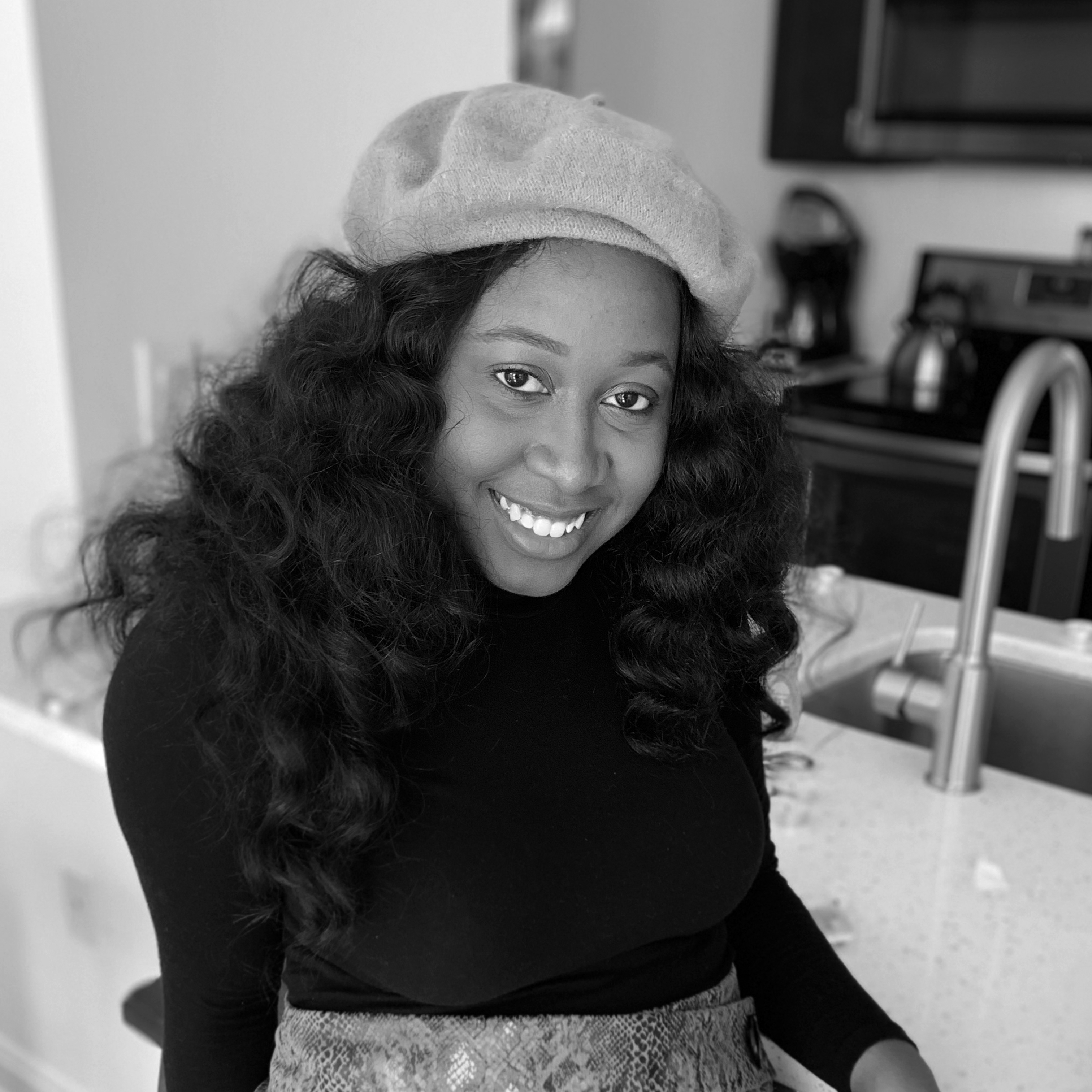 Headshot of Ermida, smiling, wearing a beret