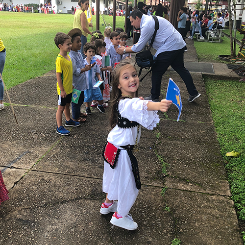 Lisa, dressed in traditional Kosovar clothing, waving the Kosovo flag in Panama