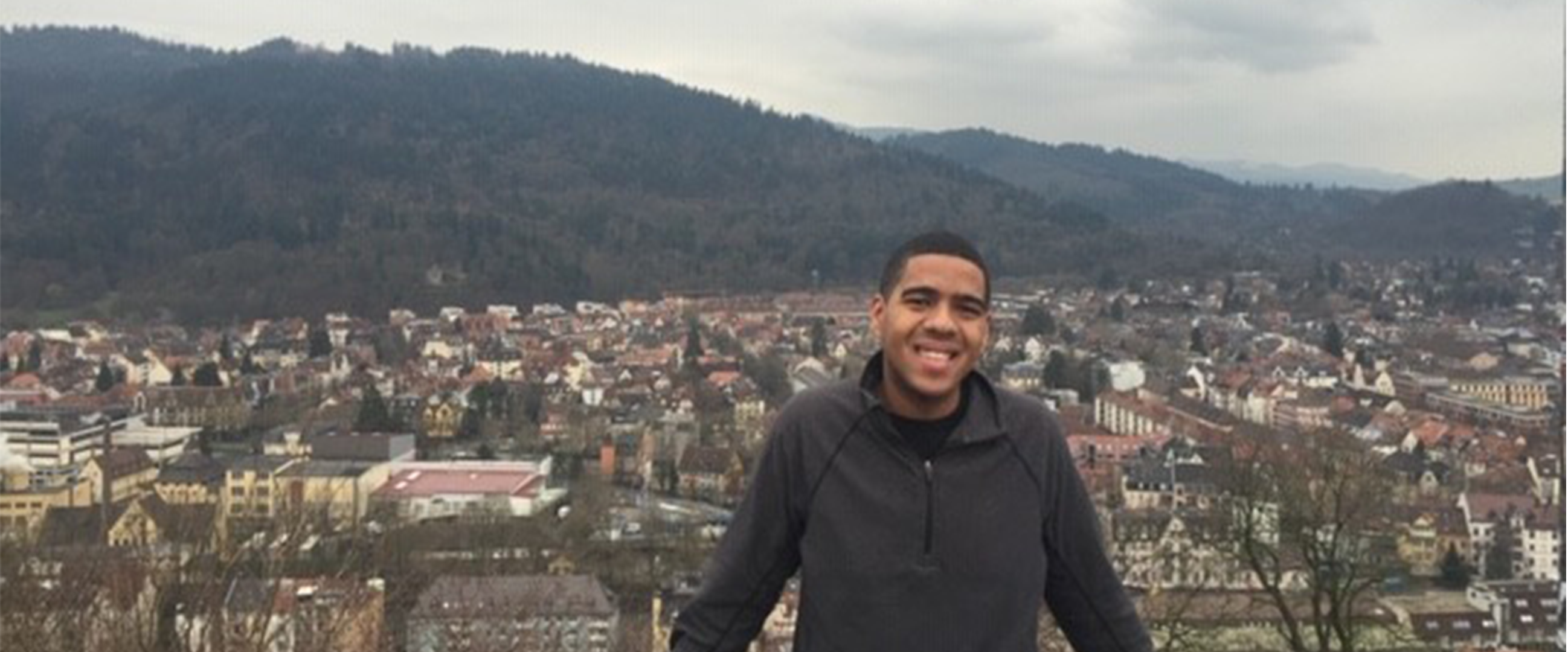 Marcus posing in Germany, with mountains in the background 