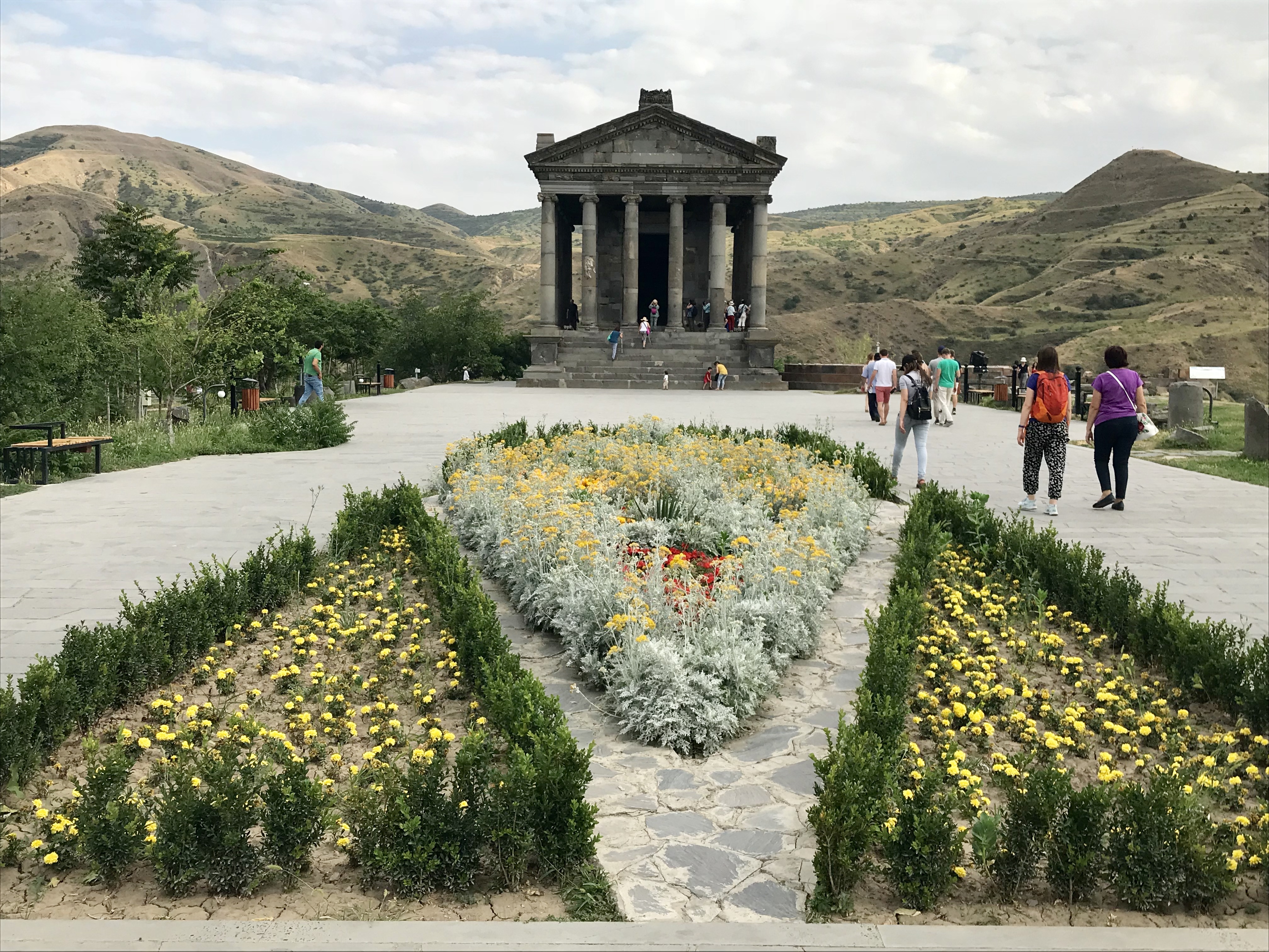 The Temple at Garni, with a bed of red and yellow flowers in the foreground.