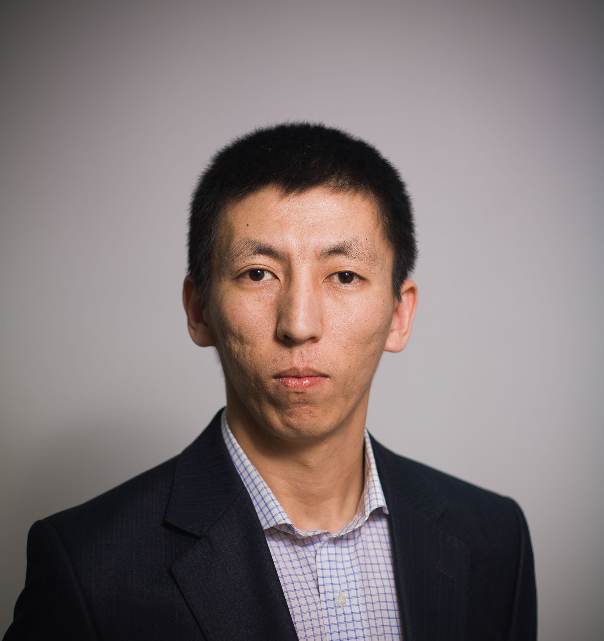 Headshot of Temur, dressed professionally, with a plain background.