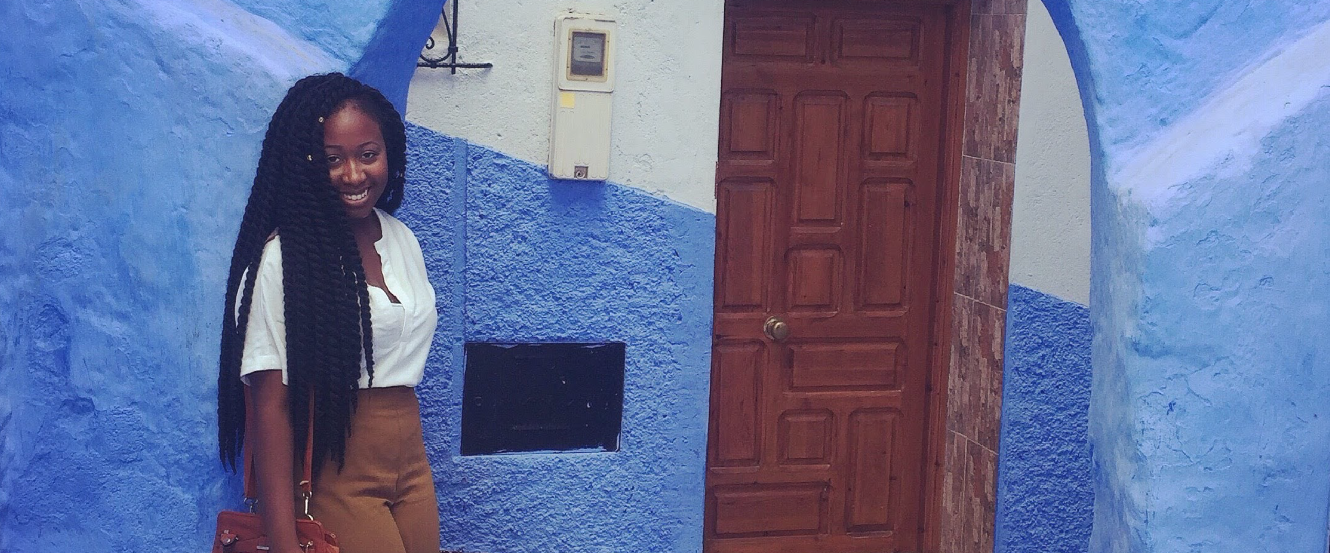 Ermida, while studying abroad in Morocco, stands against a blue wall
