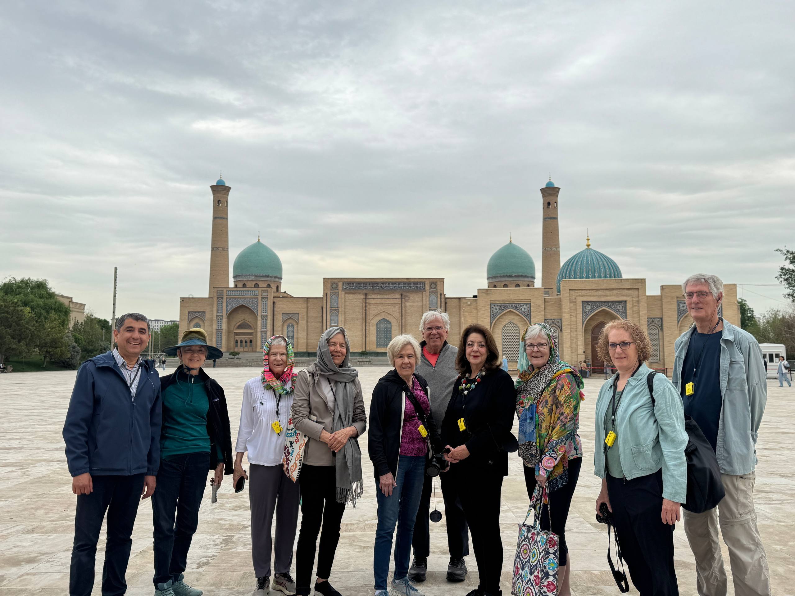 Group of travelers poses for group photo outside of turquoise blue site