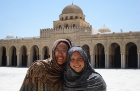 Exchange students in front of a mosque share smiles.