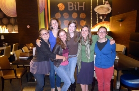 Skye posing with several YES students in Bosnia at a cafe.