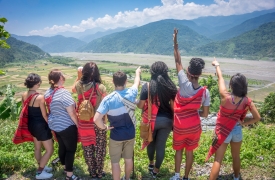 Students gather on a hillside to enjoy the view below