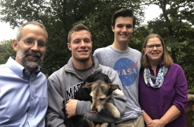 The Spawn family, including son Kyle and mother Carla (right), are all smiles with the rest of their family pose for a photo (including their cute puppy!)