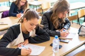 Young students work on an assignment at a large desk