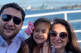 Ambassador Rudi, her husband, and daughter, smiling at the camera from the deck of a boat crossing the Panama Canal