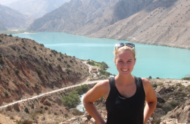 Abigail smiles for the camera while visiting a scenic mountain and lake in Tajikistan