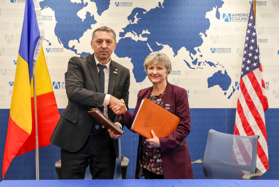 Lisa Choate shakes hands with Andrei Muraru, Ambassador of Romania to the United States