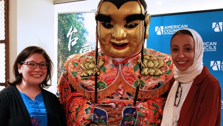 Two people pose with Taiwan art at the silent auction event. 