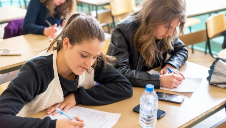 Young students work on an assignment at a large desk