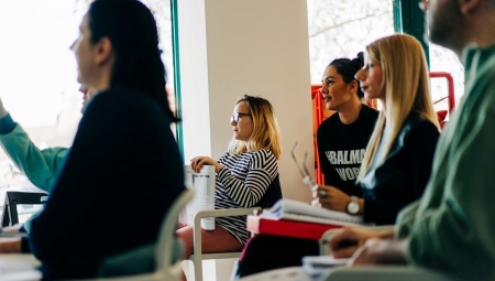 Students seated at desks facing an instructor during a BELL+ class