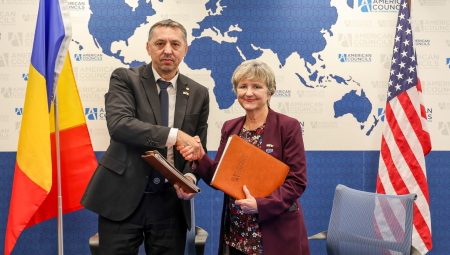 Lisa Choate shakes hands with Andrei Muraru, Ambassador of Romania to the United States
