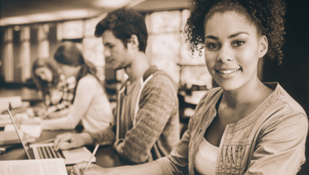 a young female student, at her computer, smiles 
